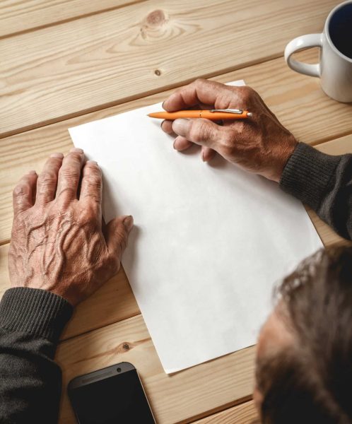 The old man wrote a testament, sitting at a wooden table