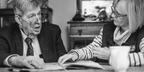 Estates planning expert Martin Wollaston sitting at a table talking to a female client.